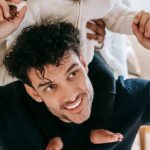 Positive Culture - Happy Muslim mother embracing black baby sitting on father