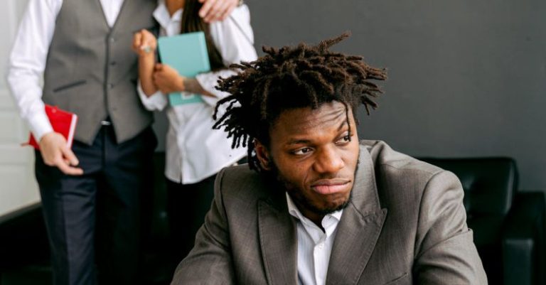 Office Politics - Frustrated Office Worker with his Colleague Laughing Behind his Back