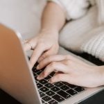 Freelance Search - Crop woman typing on laptop on bed