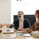 Recruiter Handshake - Man in Black Suit Jacket Sitting Beside Woman in Brown Long Sleeve Shirt