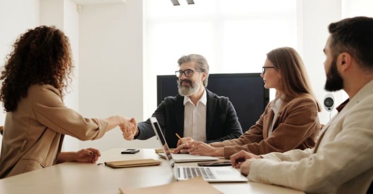 Recruiter Handshake - Man in Black Suit Jacket Sitting Beside Woman in Brown Long Sleeve Shirt