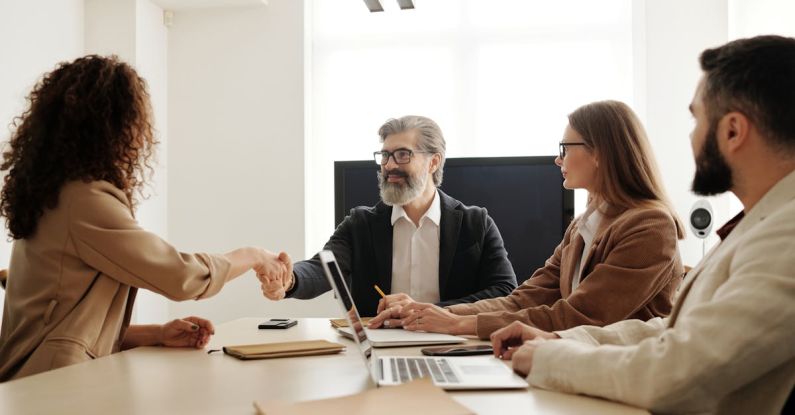 Recruiter Handshake - Man in Black Suit Jacket Sitting Beside Woman in Brown Long Sleeve Shirt