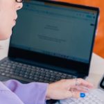 Professional Summary - A woman in a purple shirt is using a laptop