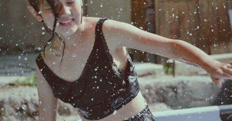 Action Verbs - A girl in a black top and shorts splashing water