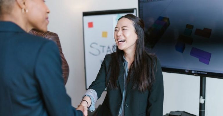 Networking Handshake - Woman in Black Blazer Smiling