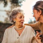 Peer Interaction - Joyful adult daughter greeting happy surprised senior mother in garden