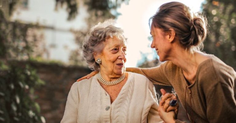 Peer Interaction - Joyful adult daughter greeting happy surprised senior mother in garden